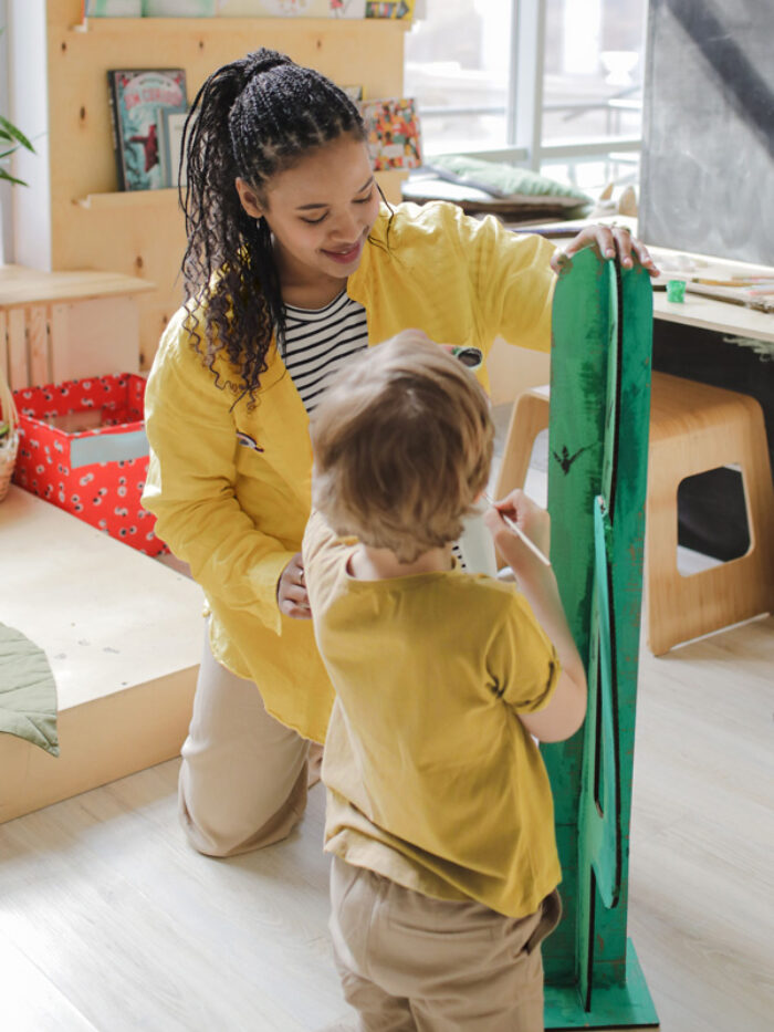 Daycare worker and child making a cactus craft