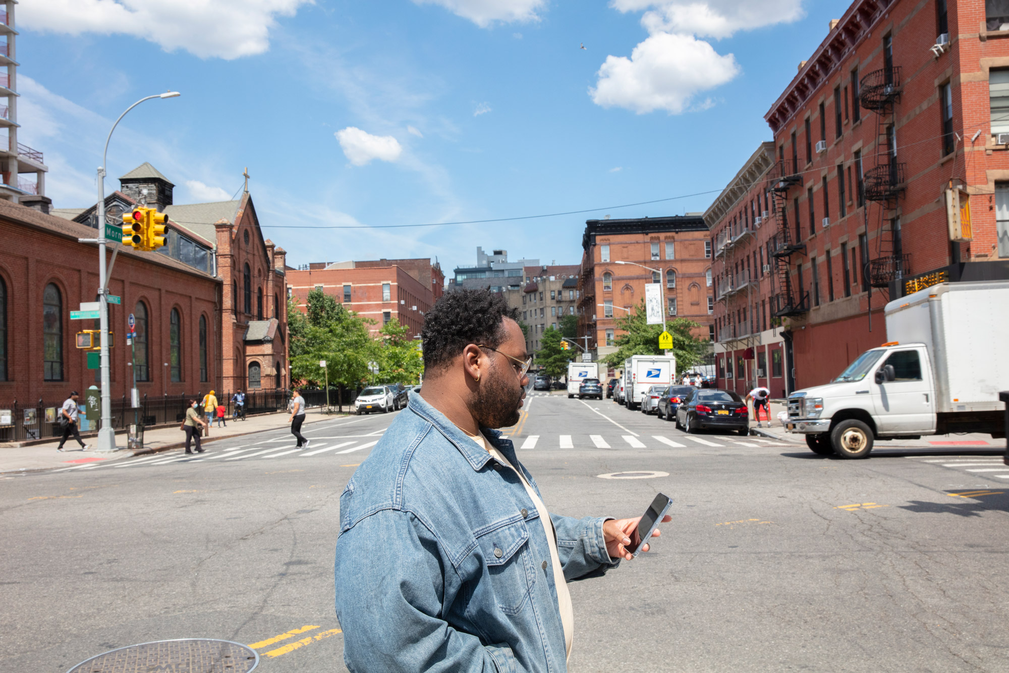 Man crosses the street while looking at his phone