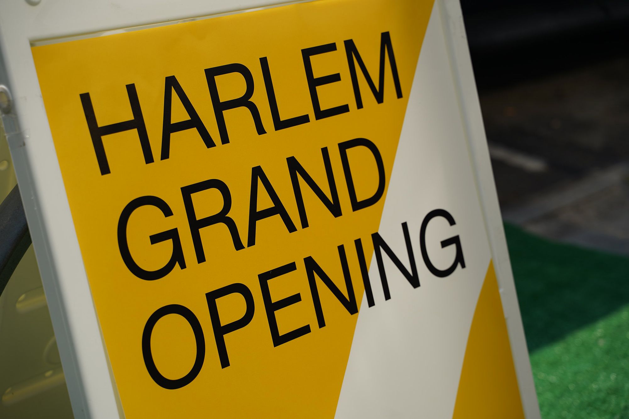 a sign saying Harlem grand opening