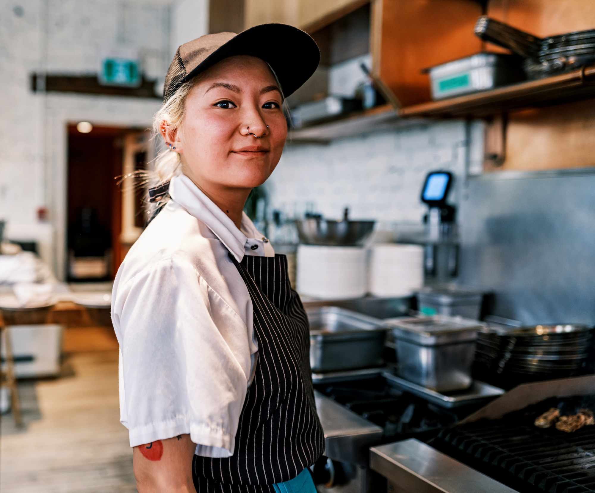 A portrait of a woman working in a commercial kitchen