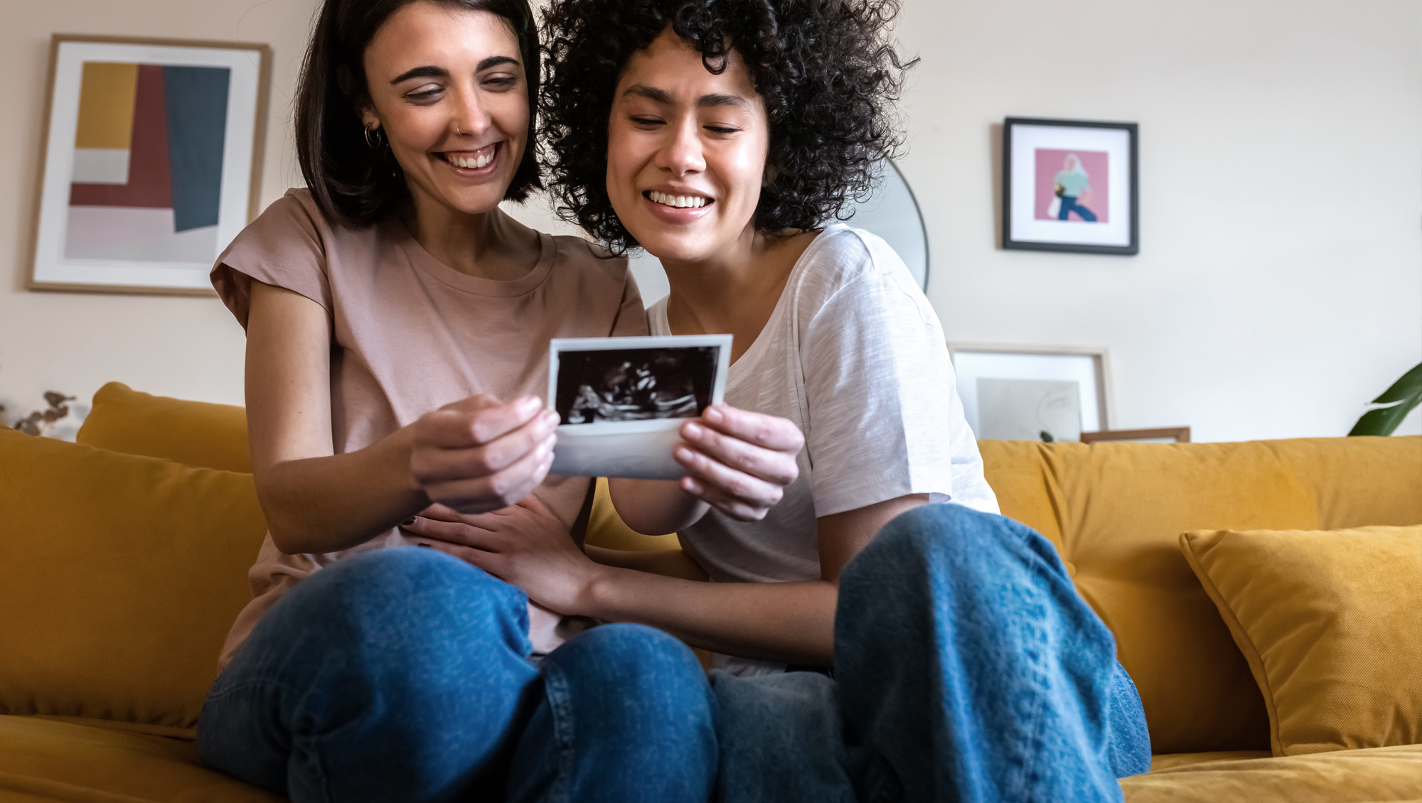 Two women smile as they look at a sonogram image