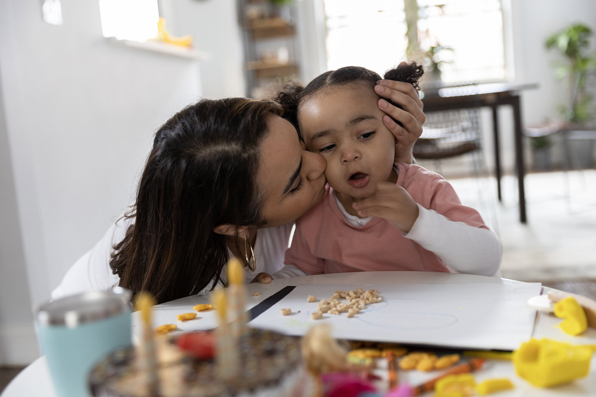 A mother kissing and hugging her child, representing the security of MetroPlusHealth Individual & Family Plans.