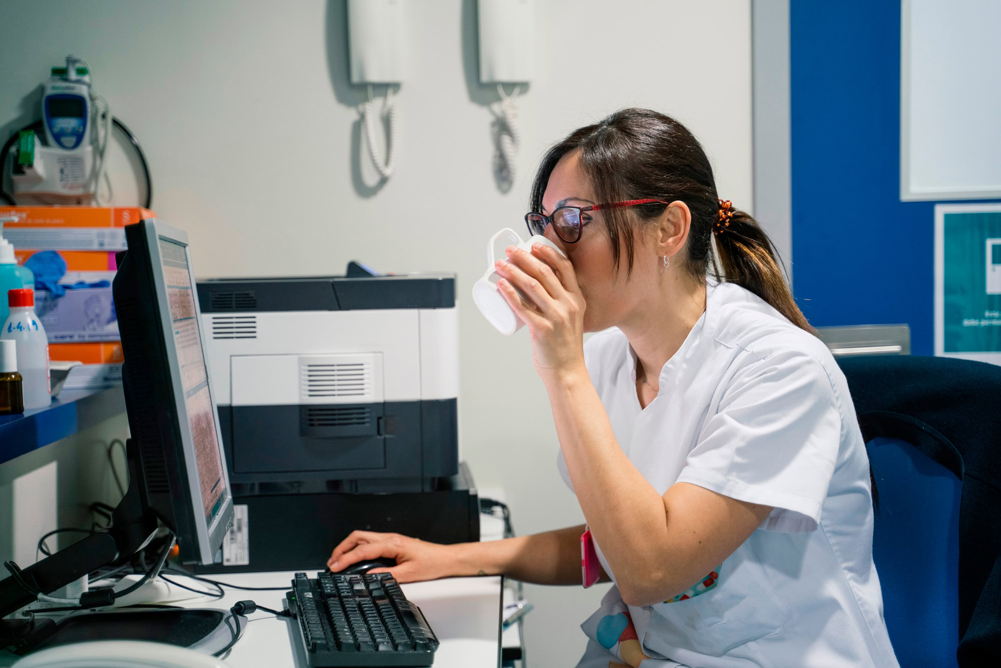 Doctor using a laptop and reviewing forms, representing MetroPlusHealth’s online provider tools.