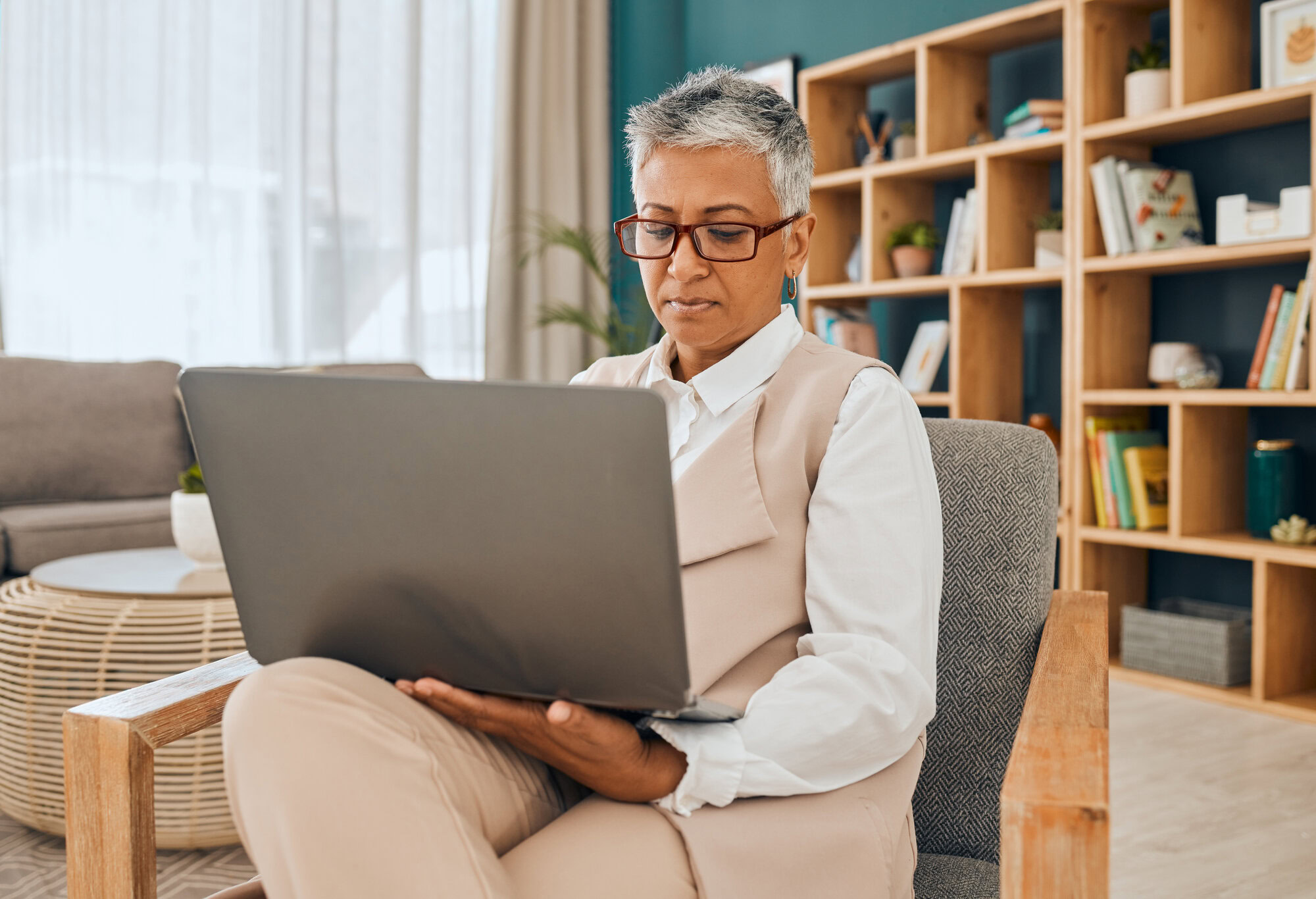 Mature psychologist, computer work and serious psychology doctor doing research in office. Therapist, reading and digital data planning of a mental health worker looking at online counseling notes