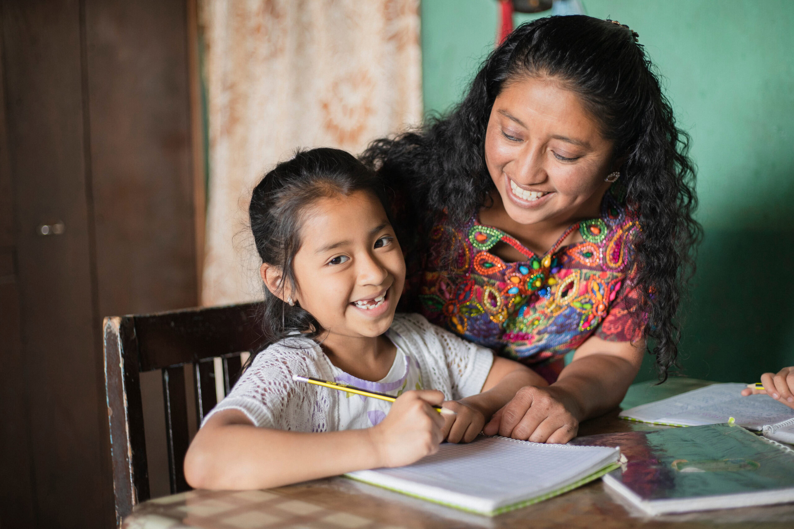Hispanic mom helping her little daughter do her homework – Mom t