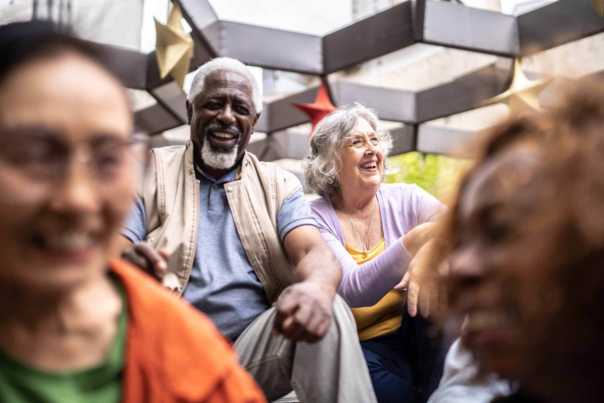 Senior friends talking sitting on ground outdoors