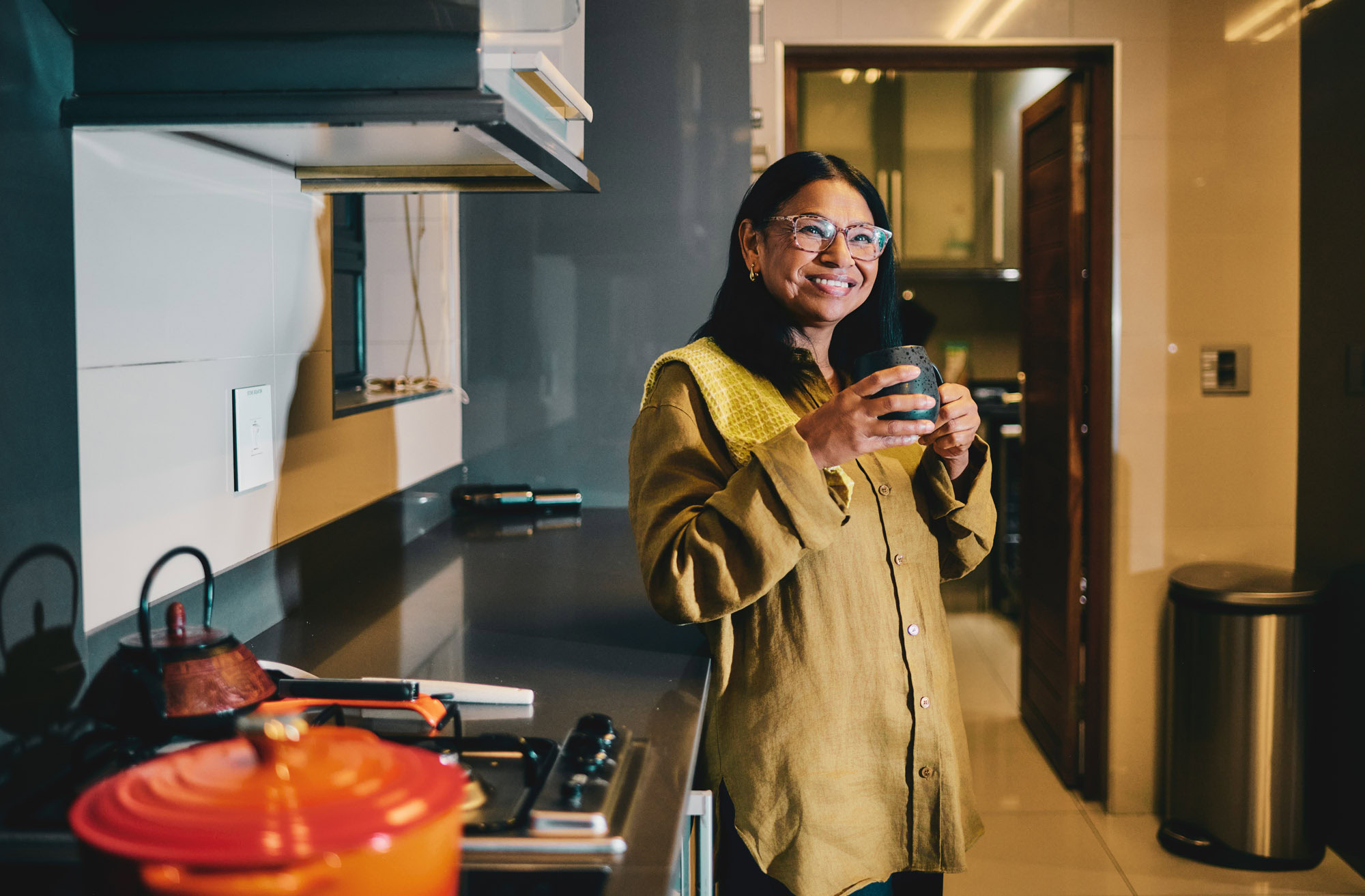 Woman Holding A Glass Drinking In Modern Kitchen Lifestyle Setting At Home